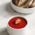 Erdbeermarmelade mit Vanille serviert mit Bauernbrot — köstlicher Fruchtaufstrich auf frischem Brot