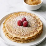 Pfannkuchen serviert mit Apfelmus — klassische Kombination formvollendet auf weißem Porzellan