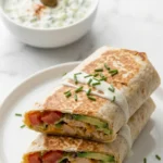 Hähnchen Avocado Ranch Burritos serviert mit Tzatziki — appetitlich halbierte Wraps formvollendet präsentiert