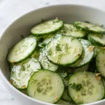 Erfrischender Gurkensalat mit Kräuterdressing frisch zubereitet — feine Gurkenscheiben in Kräuterdressing