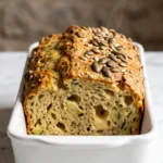Zucchini-Käsebrot von Dominique frisch zubereitet — goldbraune Kruste mit Kürbiskernen